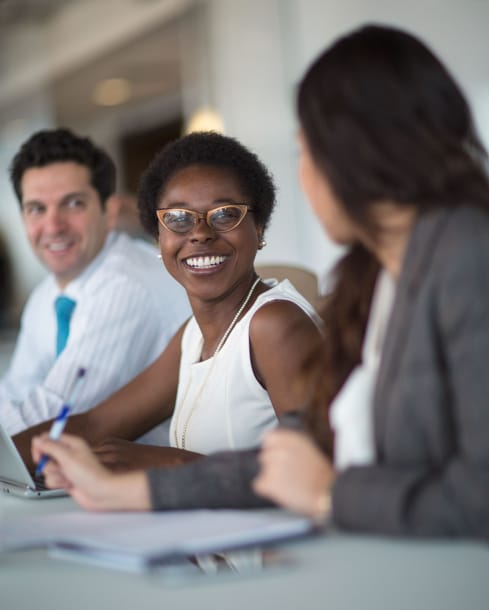Three colleagues sitting and smiling
